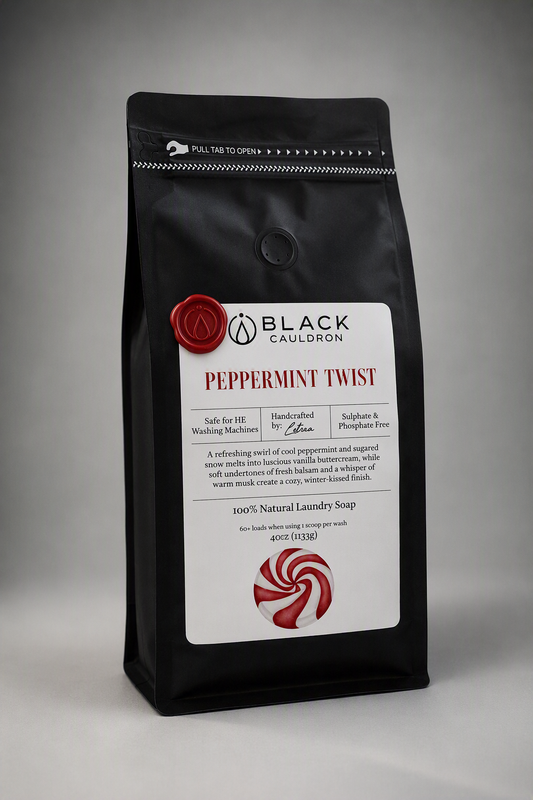 A black stand-up pouch of Black Cauldron Peppermint Twist laundry soap, featuring a white label with red text and a red-and-white swirl illustration, photographed on a neutral gray background.