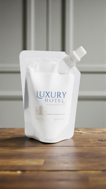 White refill pouch labeled 'Luxury Hotel' on a wooden surface with a gray background