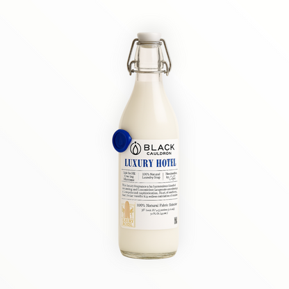 Glass bottle of Black Cauldron Luxury Hotel fabric conditioner softener on a white background